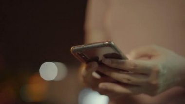 Genç gezgin Asyalı kadın, Bangkok 'ta bir gece eve cep telefonuyla gitmek için taksi çağırma başvurusunu kullanıyor. Öğrenci kız dışarıda dinlenirken internet üzerinden akıllı telefon sohbeti yapıyor..