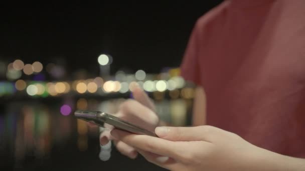 Voyageur La blogueuse asiatique voyage dans la rue la nuit dans la ville de Bangkok, Jeune femme utilisant un téléphone portable pour vérifier les médias sociaux près de la rivière en milieu urbain. Voyage touristique vacances d'été en Thaïlande .