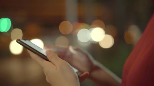 Jeune voyageuse asiatique utilisant l'application pour appeler un taxi arriver à la maison par téléphone mobile la nuit de la rue dans la ville de Bangkok. Étudiant fille en utilisant smartphone bavarder en ligne tout en se relaxant en plein air .