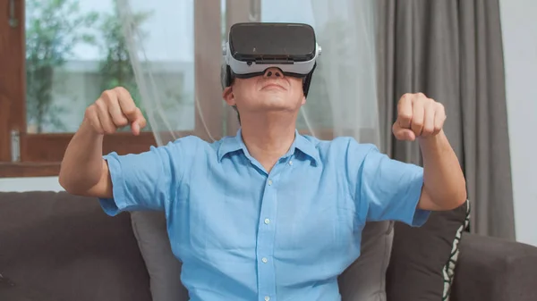 Asiatische Senioren spielen zu Hause. Asiatische ältere chinesische Männer glücklich Spaß und virtuelle Realität, VR-Spiele, während liegendes Sofa im Wohnzimmer zu Hause Konzept. — Stockfoto
