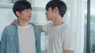 Asyalı eşcinsel çift evde ayakta ve sarılma odasında. Genç yakışıklı Lgbtq + erkekler mutluluk öpücüğü. Birlikte dinlenin. Sabah konseptinde modern mutfakta romantik zaman geçirin..
