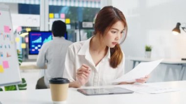 Başarılı yönetici Asya 'lı genç iş kadını gündelik kıyafet çizimi, yazımı ve dijital tabletle kalem kullanımı modern ev ofisinde ilham arama fikirleri düşünme süreci..