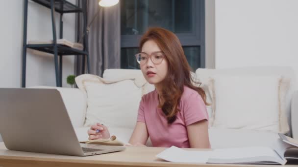 若いアジアの10代の女の子の学生の距離は オンライン教師とのレッスンを学び 自宅から自宅のリビングルームでコンピュータのラップトップ上で勉強します 社会的距離 コロナウイルス予防の隔離 — ストック動画