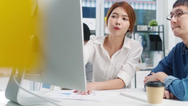 小さな近代的な都市部のオフィスで若いアジアのビジネスマンやビジネスマンのミレニアルグループ 日本人男性上司指導者インターンや新入社員韓国人女の子が困難な任務を支援 — ストック動画