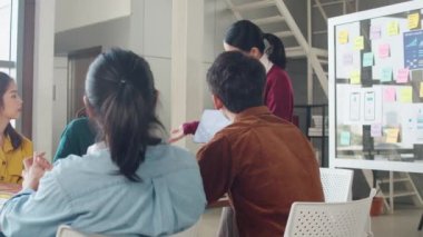 Asya 'lı genç yaratıcı insanlar, modern ofiste iş sunumu fikirlerini mobil uygulama yazılım tasarımı projesini yürüten beyin fırtınası fikirleriyle buluşuyor. İş arkadaşı takım çalışması konsepti