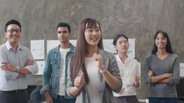 İş kadını ve iş kadını portresi. Gündelik kıyafetlerle kameraya bakıp yaratıcı ofis işyerindeki başarıyı kutluyorlar. Çeşitli Asya erkek ve dişi başlangıçta birlikte dururlar..