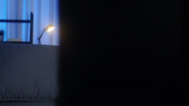 Genç Asyalı bayan TV izlerken mutlu bir kahkaha ve televizyon dizisi filmi seyrederken gece evdeki oturma odasında kanepede oturuyor. Sosyal uzaklık, koronavirüsün önlenmesi için karantina.