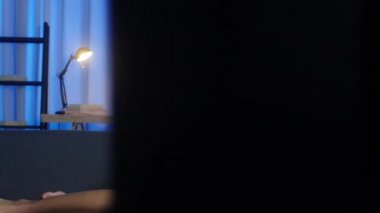 Genç Asyalı bir bayan TV izlerken mutlu bir şekilde kahkaha atar, televizyon dizisi seyreder ve geceleri oturma odasında kanepede uzanır. Sosyal uzaklık, koronavirüs önleme konsepti için karantina.