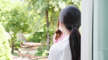 Genç Asyalı bayan restoran personeli içeri girmeden önce kızıl ötesi termometre ya da ısı tabancası kullanarak koruyucu yüz maskesi takıyor. Corona virüsünden sonra yaşam tarzı yeni normal.