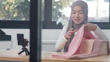 Asya moda etkisinde olan Müslüman kadınlar kamera yayınını kullanıyor ve ofiste kıyafet, ürün, e-ticaret yayını satmak için canlı yayın yapıyorlar. Evden çalışıyor, koronavirüsü önlemek için karantina altında..