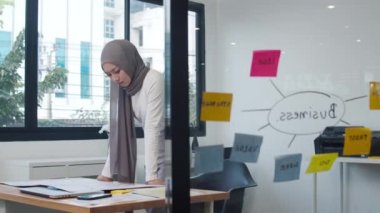 Asyalı müslüman bayanın çizim planı yeni normal ofiste kağıt üzerinde bilgi anımsatıcılığı yapmak. Evden çalışmak, uzaktan çalışmak, kişisel izolasyon, sosyal uzaklık, koronavirüs önleme için karantina.
