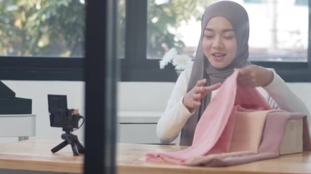 アジアのファッション影響力のデザイナーイスラム教徒の女性は オフィスでオンラインで服 電子商取引放送を販売するためにカメラストリーミングやライブを使用しています 自宅からの作業 コロナウイルスの予防のための隔離 — ストック動画