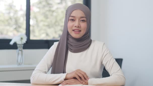 アジアのイスラム教徒の女性は カメラを見て 新しい普通のオフィスでのビデオ通話の計画について同僚に話します 自宅からの作業 遠隔作業 社会的距離 コロナウイルスの隔離 — ストック動画