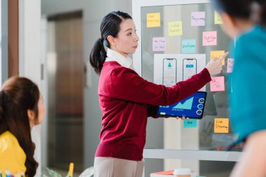 Asya 'lı genç yaratıcı insanlar, modern ofiste iş sunumu fikirlerini mobil uygulama yazılım tasarımı projesini yürüten beyin fırtınası fikirleriyle buluşuyor. İş arkadaşı takım çalışması konsepti