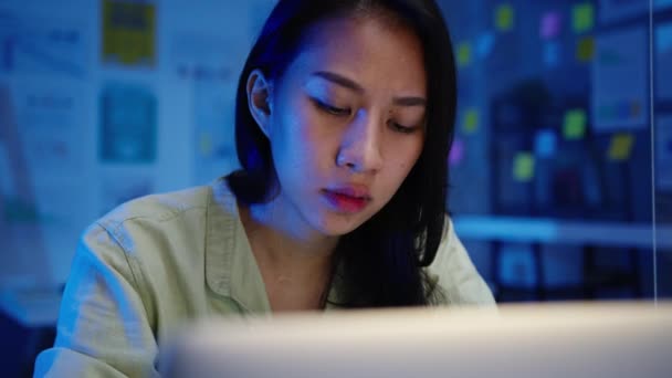 新しい普通のオフィスでノートパソコンのハードワークを使用してフリーランスのアジアの女性 夜間の自宅の過負荷から働く リモートワーク 自己分離 社会的距離 コロナウイルスの予防のための隔離 — ストック動画
