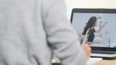 Dizüstü bilgisayar mesafesini kullanan Asya 'lı genç kız üniversite öğrencisi evde internetten uzaktan eğitim alan bayan öğretmenden ders alıyor. Corona virüsünün önlenmesi için sosyal mesafe ve karantina.