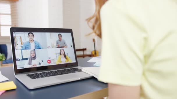 아시아 사업가는 노트북을 사용하여 동료들에게 집에서 거실에서 일하는 비디오 미팅의 — 비디오