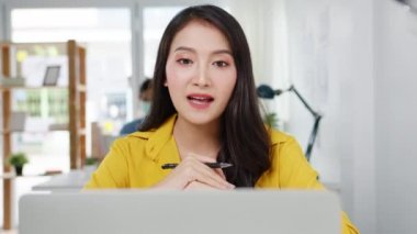 İş kadını Asyalı iş kadını sosyal mesafesi virüs önleme için yeni normal bir durum içindeyken iş arkadaşlarına bilgisayar sunumu yaparak ofiste çalışırken planlama hakkında bilgi veriyor. Corona virüsünden sonraki yaşam.
