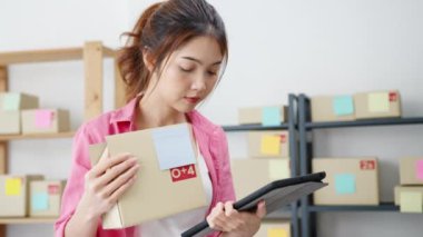 Genç Asyalı girişimci iş kadını hisse senedi alım siparişini kontrol ediyor ve merkez ofisindeki tablet bilgisayarlara kaydediliyor. Küçük işletme sahibi, çevrimiçi pazar teslimatı, yaşam tarzı serbest konsepti.