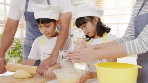 就学前の子供を持つ幸せな笑顔の若いアジアの日本の家族は 午前中に現代的なキッチンの家で朝食の食事のための楽しいベーキングペストリーやパイを持っています パン屋は生地をこねクッキーを焼く — ストック動画