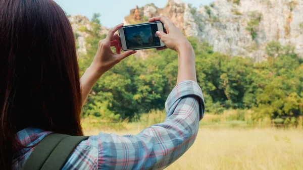 Iloinen Nuori Matkustaja Aasian Nainen Reppu Älypuhelimella Ottaa Kuvan Vuoristojärvellä — kuvapankkivalokuva