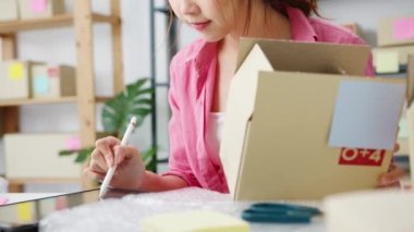 Genç Asyalı girişimci iş kadını hisse senedi alım siparişini kontrol ediyor ve merkez ofisindeki tablet bilgisayarlara kaydediliyor. Küçük işletme sahibi, çevrimiçi pazar teslimatı, yaşam tarzı serbest konsepti.