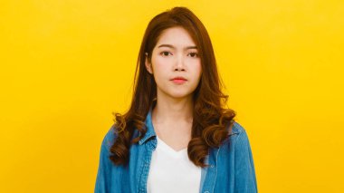 Yüzünde olumlu bir ifadeyle gülümseyen sevimli Asyalı kadın, geniş bir şekilde gülümsüyor, günlük giysiler içinde ve sarı arka plandan kameraya bakıyor. Mutlu, mutlu, mutlu kadın başarıya sevinir..