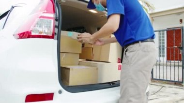 Asya 'lı gönüllü teslimatçı, yüz maskesi takıyor. Paket paketini arabayla teslim edip müşteriye gönderiyor. Paket alışverişi yiyecek teslimatı, yaşam tarzı Corona virüsü konseptinden sonra yeni normal..