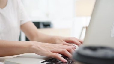 Serbest çalışan Asyalı genç iş kadını evde çalışırken dizüstü bilgisayar kullanıyor. Evden çalışmak, uzaktan çalışmak, kişisel izolasyon, sosyal uzaklık, korona virüsünün önlenmesi için karantina.