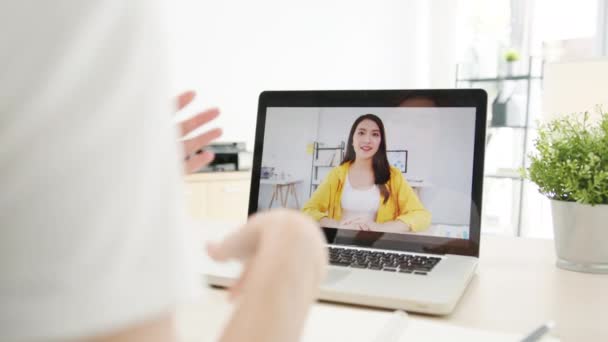 아시아 사업가는 노트북을 사용하여 동료들에게 집에서 거실에서 일하는 비디오 미팅의 — 비디오