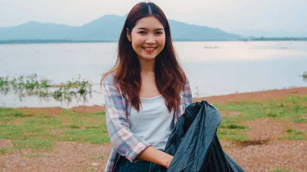アジアの若い女性ボランティアの肖像画は ビーチでプラスチックボトルの廃棄物や黒いゴミ袋を保持自然をきれいに保つのに役立ちます 環境保全汚染問題の考え方 — ストック写真