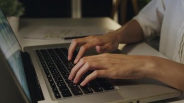Serbest çalışan Asyalı kadın evdeki oturma odasında dizüstü bilgisayar kullanıyor. Geceleri ev aşırı yükleme, uzaktan çalışma, kendini izole etme, sosyal mesafeler, korona virüsünün önlenmesi için karantina.