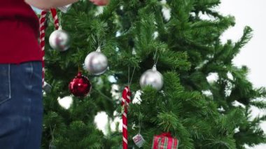 Noel ağacında süslerle süslenmiş Asyalı bir kadın ve evde yeni yıl festivali. Xmas kutlaması etkinlik hazırlığı ya da kış bayramı festivali kapalı mekanda parti konsepti. Yakın çekim..