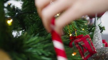 Noel ağacında süslerle süslenmiş Asyalı bir kadın ve evde yeni yıl festivali. Xmas kutlaması etkinlik hazırlığı ya da kış bayramı festivali kapalı mekanda parti konsepti. Yakın çekim..