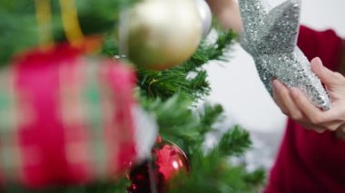 Noel ağacında süslerle süslenmiş Asyalı bir kadın ve evde yeni yıl festivali. Xmas kutlaması etkinlik hazırlığı ya da kış bayramı festivali kapalı mekanda parti konsepti. Yakın çekim..