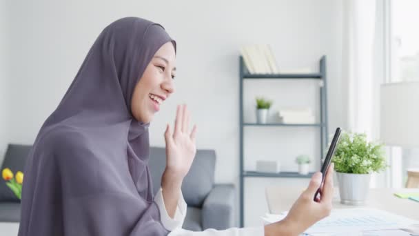 年轻的亚洲穆斯林女商人一边从家里客厅远程工作 一边通过视频聊天在网上与朋友聊天 社会疏离 电晕病毒的检疫 — 图库视频影像
