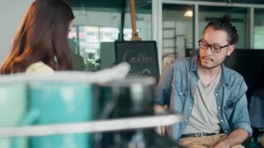 Kafe restoranındaki tezgahın arkasında duran tüketiciye sıcak kahve bardağı servis eden genç Asyalı bayan barista. Küçük işletme, yiyecek ve içecek, hizmet zihin konsepti.