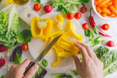 Taze yemek hazırlama adam masada sağlıklı salata detoks. Sarı kırmızı biber kesme. Portre