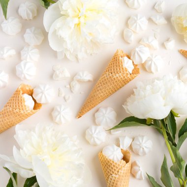 Yaz bahar arka plan ihale. Yukarıdan şakayık, kiraz, dondurma waffle koniler ve merengue üzerinde bej ile görüntüleyin. Kopya alanı ile üstten görünüm