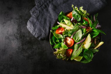 Kase karanlık tablo arka plan üzerinde hazır servis salata. Yukarıdan görüntüleyin. Sağlıklı gıda kavramı detoks