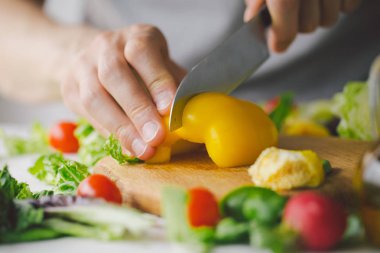 Taze yemek hazırlama adam masada sağlıklı salata detoks. Sarı kırmızı biber kesme. Portre