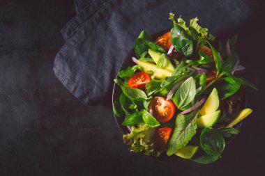 Kase karanlık tablo arka plan üzerinde hazır servis salata. Yukarıdan görüntüleyin. Sağlıklı gıda kavramı detoks