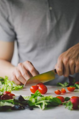 Taze yemek hazırlama adam masada sağlıklı salata detoks. Sarı kırmızı biber kesme. Portre