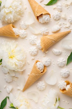 Yaz bahar arka plan ihale. Yukarıdan şakayık, kiraz, dondurma waffle koniler ve merengue üzerinde bej ile görüntüleyin. Kopya alanı ile üstten görünüm