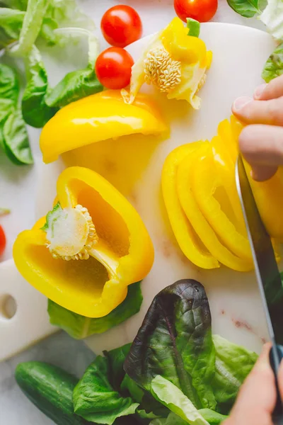 Taze yemek hazırlama adam masada sağlıklı salata detoks. Sarı kırmızı biber kesme. Portre