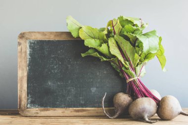 Taze beetroots gri arka plan arkasında kurulu ile ahşap masa yerleştirilir. Doğa, çevre, biyolojik, vegan veya vejetaryen sağlıklı yaşam kavramı. Yatay kopya alanı ile. 