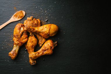 Lezzetli iştah açıcı Barbekü tavuk budu ile baharat siyah arduvaz arka plan üzerine kavrulmuş. Yukarıdan kopya alanı ile göster. 