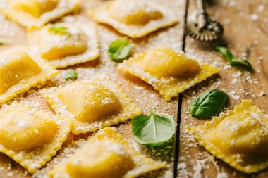 Lezzetli çiğ ravioli ile un ve fesleğen ahşap arka plan üzerinde. İtalyan ravioli yapma işlemi. Portre