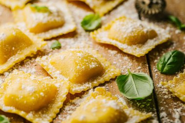 Lezzetli çiğ ravioli ile un ve fesleğen ahşap arka plan üzerinde. İtalyan ravioli yapma işlemi. Portre
