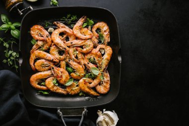 Lezzetli, kavrulmuş karides, tavada baharat ve siyah arka planda malzemeler. Kopya uzayı ile Üst Görünüm. Yemek Geçmişi İtalyan Mutfağı Konsepti